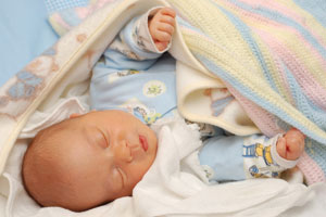 Baby in seiner Entwicklung schläft unter Babydecke Baby in seiner Entwicklung schläft unter Babydecke