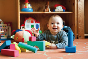 Baby spielt in Babyzimmer mit Babyausstattung Baby spielt in Babyzimmer mit Babyausstattung