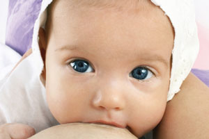 Baby beim Stillen saugt an der Brust Baby beim Stillen saugt an der Brust