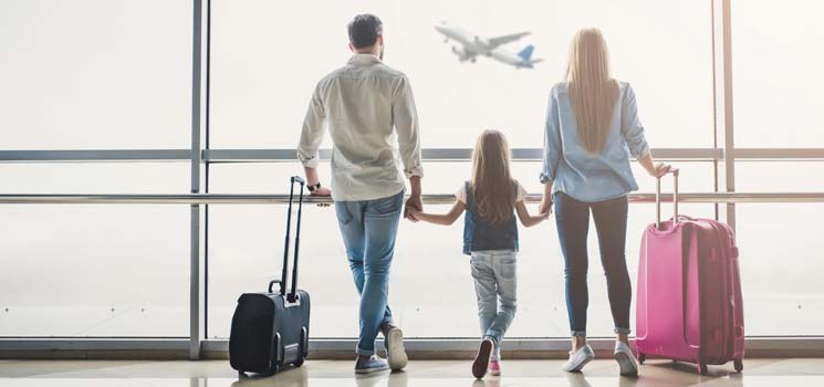 Eltern mit Kindern vor der Weltreise am Flughafen
