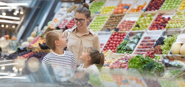 Mutter mit Kindern beim Lebensmittelkauf