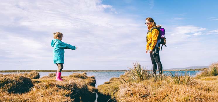 Kind lernt Selbstständigkeit mit Mutter an der See