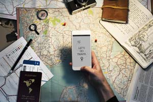 Mit Smartphone und Weltkarte die Reiseroute planen