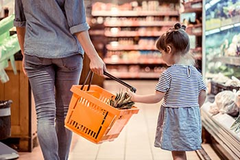 Kind hilft Mutter beim Einkaufen von Lebensmitteln Kind hilft Mutter beim Einkaufen von Lebensmitteln
