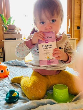 Kind spielt mit Eucabal Kinderbad-Verpackung Kind spielt mit Eucabal Kinderbad-Verpackung