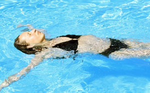 Frau im Wasser bereitet sich durch Bewegung auf die Schwangerschaft vor