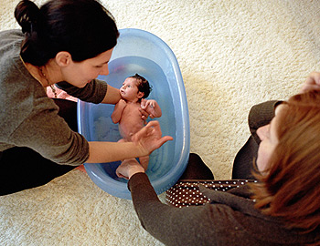 Hebamme mit zu wenig Stundenlohn zeigt Mutter das Baby-baden