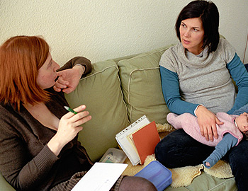 Mutter mit Baby im Gespräch mit Hebamme mit zu hoher Haftpflicht