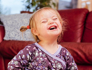 Kleinkind mit Down-Syndrom lacht Kleinkind mit Down-Syndrom lacht